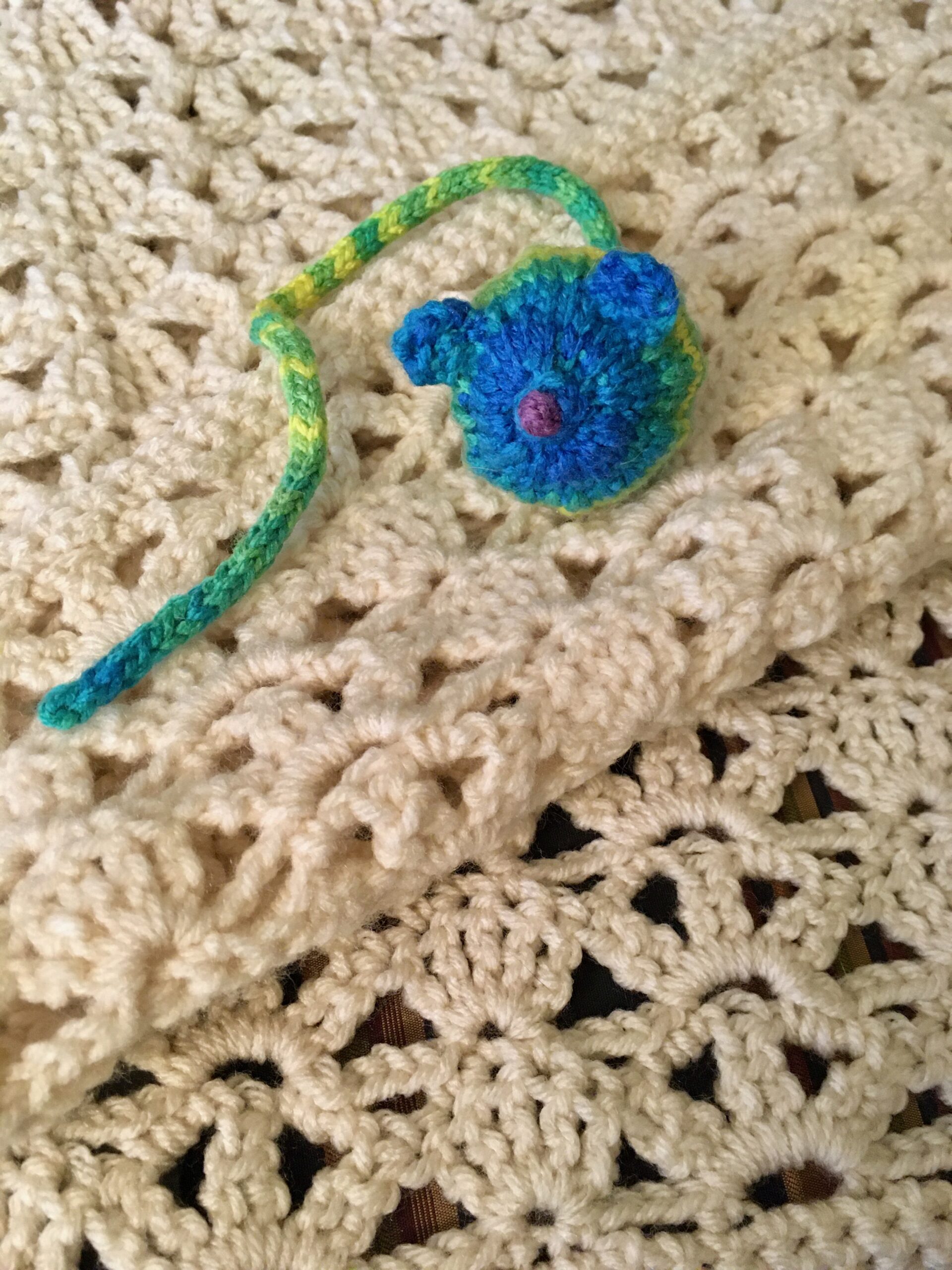 mouse toy on lacy throw pattern
